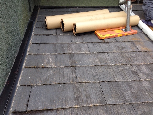 施工に向けて準備された新しい屋根材と、既存のカラーベスト屋根