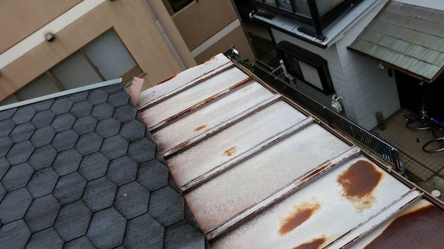 サビが進行した金属屋根とアスファルトシングル屋根の境界部分の調査状況。