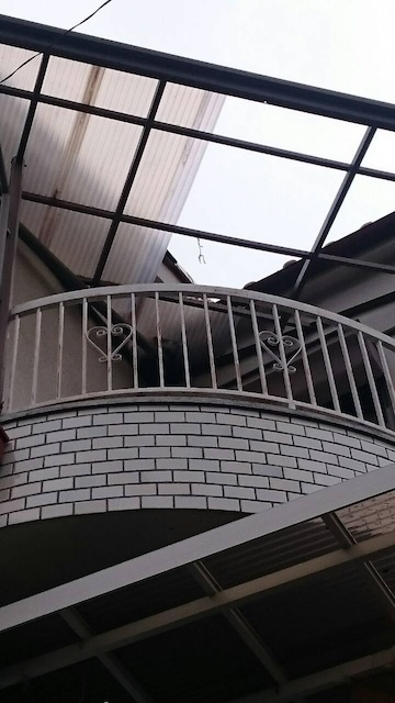  下地のアルミ骨組み（曲面形状）が露出した城陽市のベランダ屋根