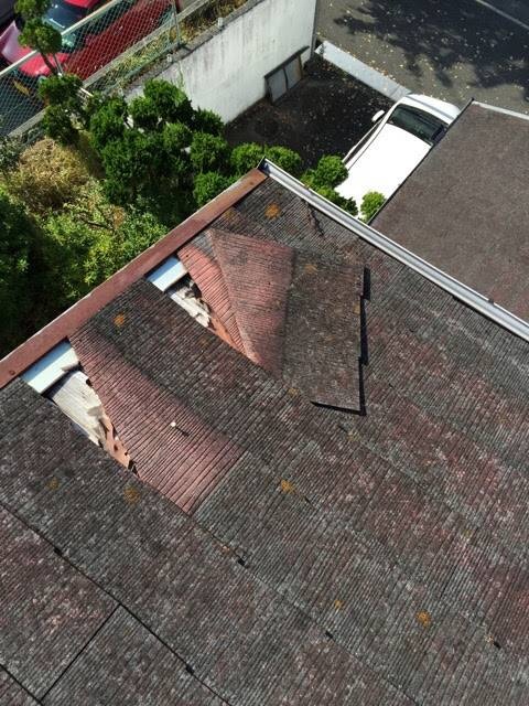 スレート屋根の層間剥離（ミルフィーユ現象）による大きなズレ落ちと欠損。塗装不可の劣化症状