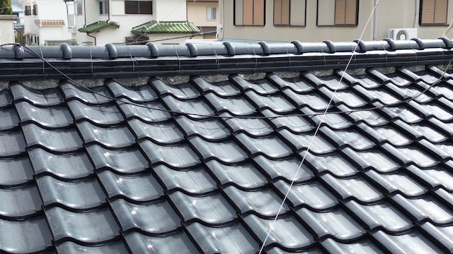  宇治市での現地調査。屋根のてっぺん（棟瓦）の下にある漆喰の黒ずみや浮きなどの劣化状況