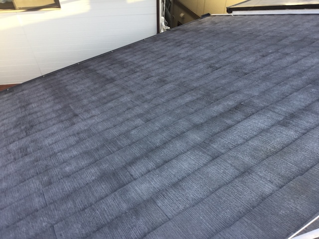 塗膜が剥がれ吸水状態にあるスレート屋根の近影