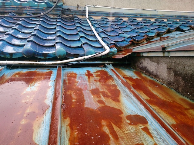 宇治市の瓦棒屋根調査。瓦との接合部である谷板金が激しく赤錆びて腐食している様子。
