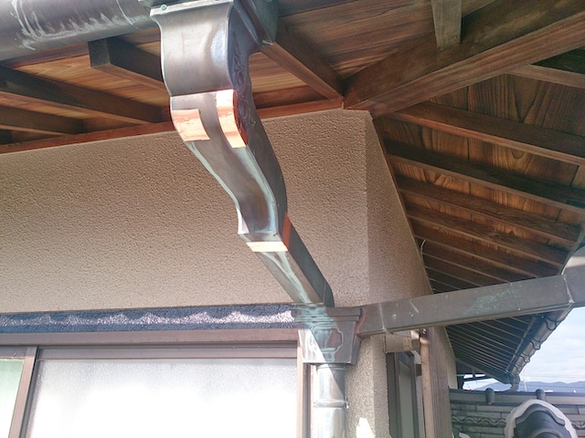 銅製雨樋の曲がり部分（呼び樋）の穴あきを補修テープで修理した様子