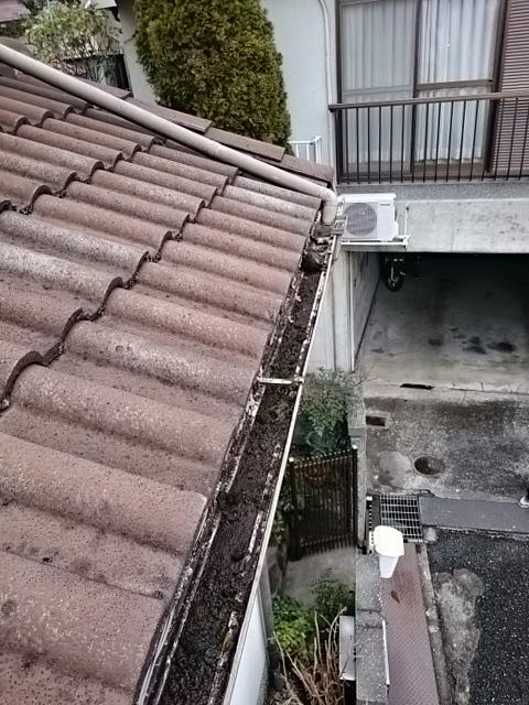 雨樋（軒樋）に土や泥が堆積し、詰まっている様子