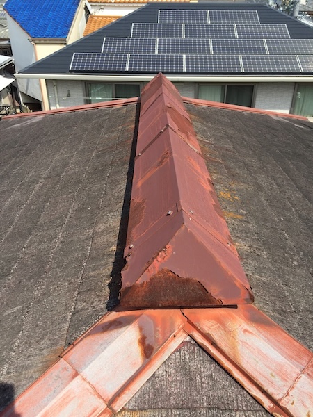 棟板金の拡大写真。塗膜が完全に剥離し、穴が開く寸前の腐食が見られる