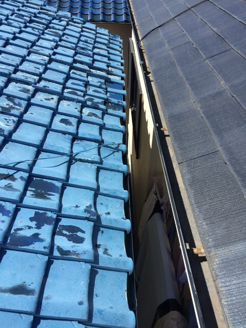 城陽市久世の屋根調査。隣家との境界部分の瓦も塗装が剥がれ落ちている