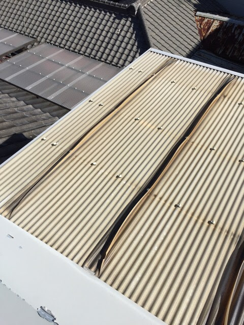 劣化したベランダ屋根の全体像。この状態から梯子を使って安全に張り替え作業を行う。