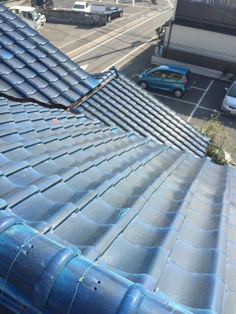  宇治市の瓦屋根全体図。雨水が集まる谷板金部分に赤サビが広がっている様子。