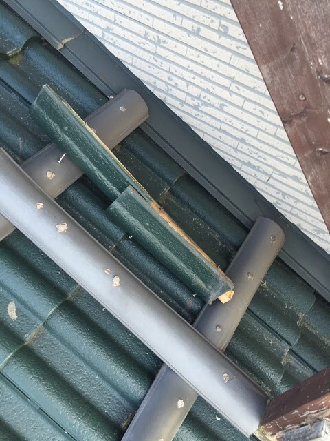  屋根の一番高い部分（棟瓦）が外れ、内部の木材（貫板）がむき出しになって腐食している状態