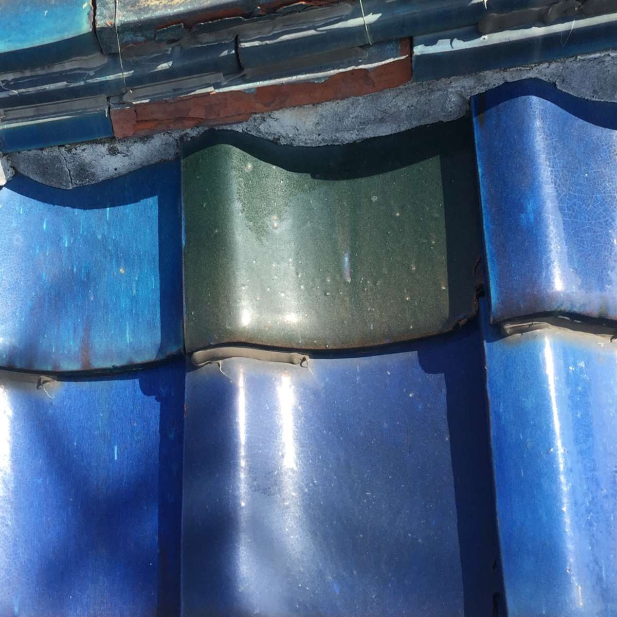 京都市南区の雨漏り調査・割れた瓦に白いコーキング（パテ）が不適切に塗られた様子