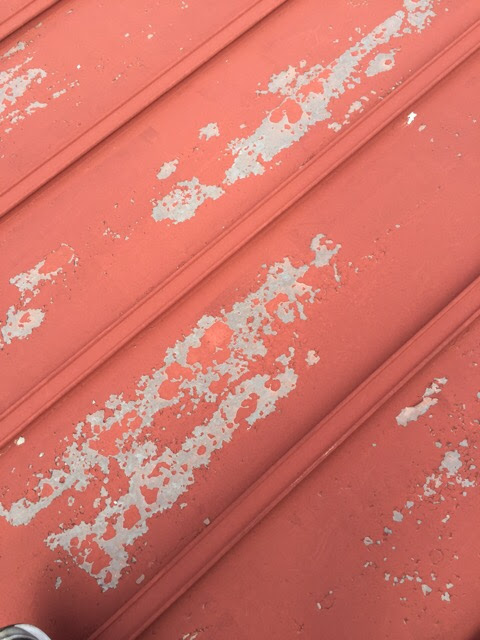 木津川市の屋根調査。元々の赤い塗装が激しく剥がれている金属屋根の表面