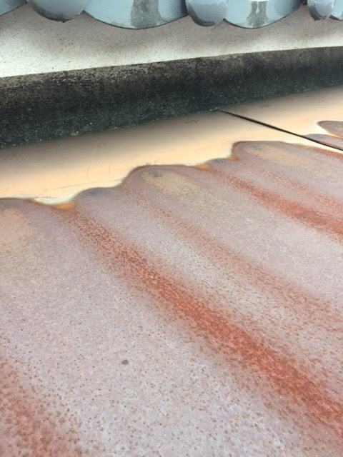 表面の保護機能が失われ、雨漏りリスクが高まっている伏見区のトタン庇