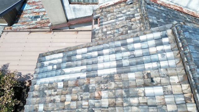 過去の補修工事による瓦の色むらとズレ。ドローン撮影による屋根瓦の接写画像