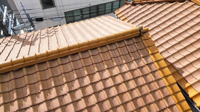 「京都市西京区の3階建て住宅にてドローン屋根点検。過去に補修された跡があり、既存の瓦との色や形状の違いを確認。新旧の取り合い部分の不具合調査」