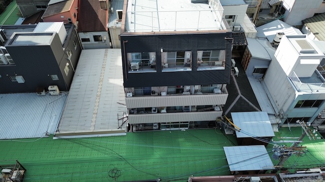 屋上防水と斜壁シングルの取り合い部分。室外機や配管周りの雨仕舞いを確認するための詳細写真。