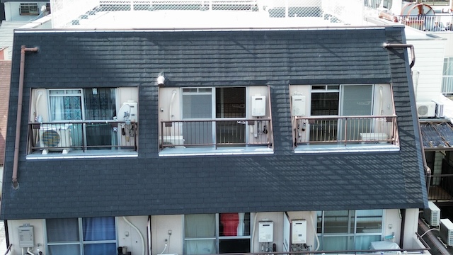 マンション3階・4階部分の斜壁の劣化状況。既存アスファルトシングルの状態を確認。