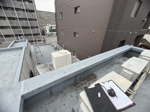 斜壁シングル貼り替え見積もりのための屋上現地調査と採寸の様子