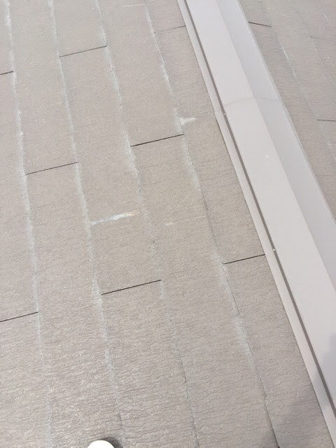 京都市左京区の屋根板金（金属部分）と白く劣化したスレート屋根の境界部分