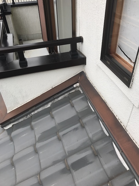久御山町で下屋の壁際角部を点検、瓦と壁の角の白い部分と雨押え板金端部の納まりを確認