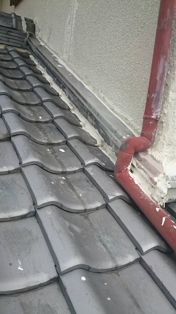 雨どいと壁際の接合部。不要なコーキングが雨水の流れを止めている様子。