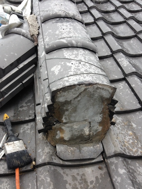 鬼瓦の土台漆喰が剥離し、中の葺き土が露出している状態